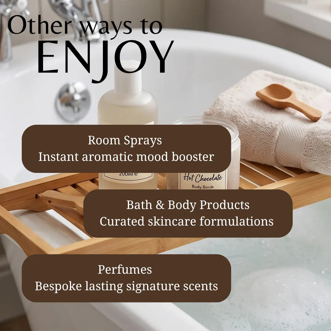 A wooden bath caddy over a bathtub holds several bath and body products, including a room spray bottle, a hot chocolate jar, and a folded towel with a wooden spoon. Large text reads 'Other ways to ENJOY' and lists room sprays, bath & body products, and perfumes.