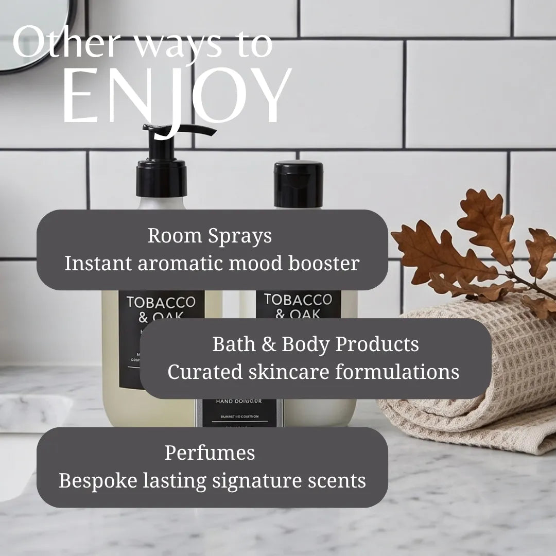 Promotional graphic for a fragrance and home fragrance collection, featuring two black pump bottles labeled Tobacco & Oak and Tobacco & Oak Wood Notes on a marble countertop. White subway tiles and a beige waffle-knit towel with dried oak leaves are in the background.