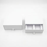 Two white drawer-style packaging boxes on a clean white background, with one closed and one open showing interior compartments.