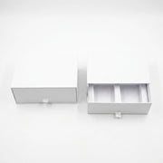 Two white drawer-style packaging boxes on a clean white background, with one closed and one open showing interior compartments.