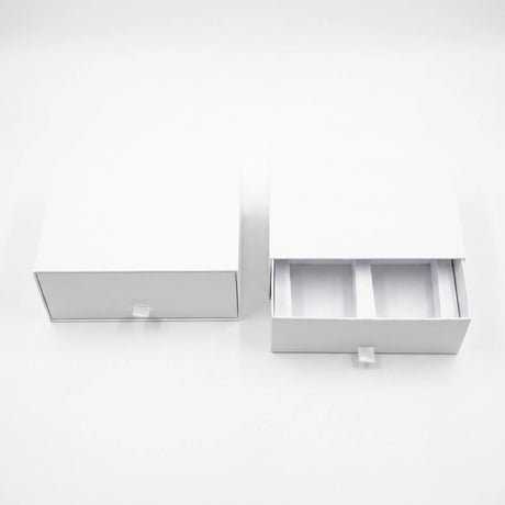 Two white drawer-style packaging boxes on a clean white background, with one closed and one open showing interior compartments.
