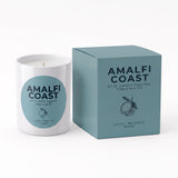 A white candle jar with a light blue circular label next to its matching light blue box, both printed with the brand name AMALFI COAST and the scent name Lemon Bergamot Amber.