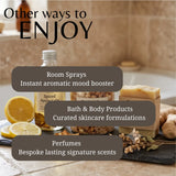 Promotional graphic for a spa or wellness product collection, featuring a bottle of spiced apple cider, a bar of soap, and sliced lemons on a stone surface with text overlays reading 'Other ways to ENJOY' and listing 'Room Sprays,' 'Bath & Body Products,' and 'Perfumes.'.