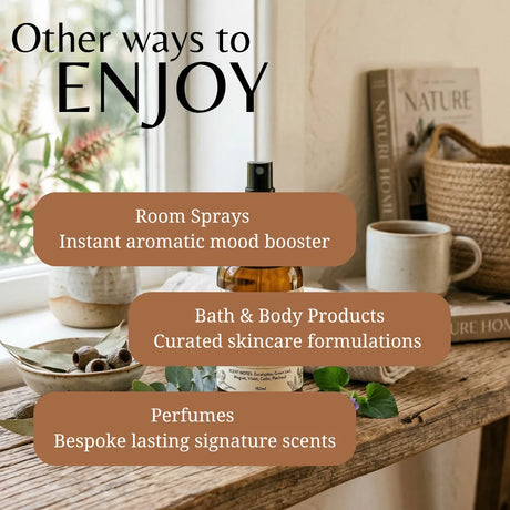 Promotional graphic with the text 'Other ways to ENJOY' over a styled interior scene. The scene shows a wooden table with a room spray bottle, a ceramic mug, books, a woven basket, and small green leaves.