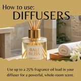 A reed diffuser bottle labeled Bali Bliss sits on a bathroom counter with a rolled towel, flowers, and large text reading 'How to use: DIFFUSERS' and usage instructions.