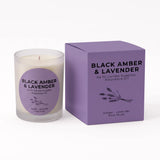 A glass jar candle with white wax next to its lavender-colored packaging box, both labeled 'BLACK AMBER & LAVENDER' by An NI Candle Supplies, on a clean white background.