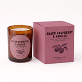 An amber glass jar candle with a round pink label next to its matching pink packaging box, both labeled 'Black Raspberry & Vanilla' by An Ni Candle Supplies, on a clean white background.