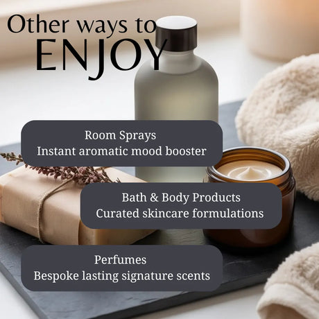 Promotional graphic for home fragrance and wellness products, featuring a frosted bottle, an amber candle jar, a wrapped gift box, and folded towels on a dark tray, with text reading 'Other ways to ENJOY' and callouts for room sprays, bath & body products, and perfumes.
