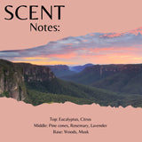 A square scent profile graphic with a landscape photo of a mountain valley at sunset across the center, a peach-pink background, and black text reading 'SCENT Notes:' at the top and scent notes at the bottom.