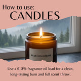 An informational graphic titled 'How to use: CANDLES' shows a lit amber glass candle jar labeled 'BLUE MOUNTAINS' in front of a window with a forest view. Text at the bottom explains fragrance oil load recommendations.