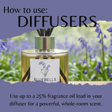 A bottle of Bluebells reed diffuser oil with black reeds, set against a blurred background of purple bluebells in a field. The image includes text overlays reading 'How to use: DIFFUSERS' and 'Use up to a 25% fragrance oil load in your diffuser for a powerful, whole-room scent.