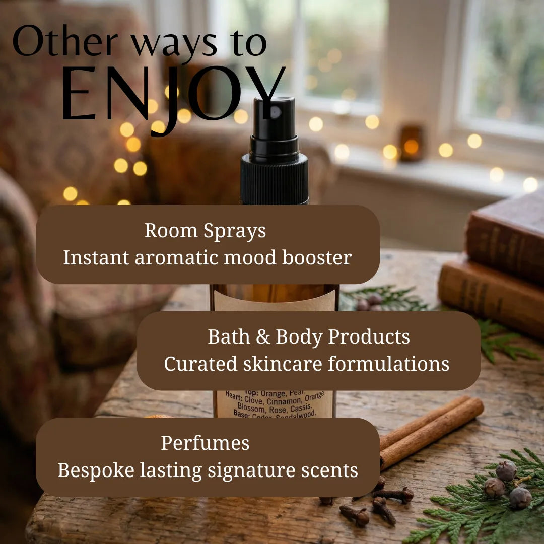 A room spray bottle displayed on a rustic wooden table with cinnamon sticks, pine needles, and books in the background, overlaid with promotional text reading 'Other ways to ENJOY' and listing room sprays, bath & body products, and perfumes.