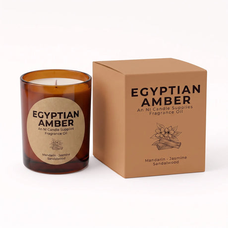 An amber glass candle jar with a round kraft paper label next to its matching brown cardboard box, both labeled 'EGYPTIAN AMBER' by An Ni Candle Supplies.