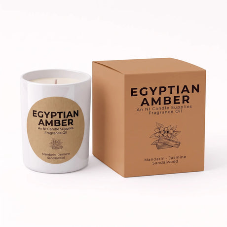 A white candle jar with a large tan circular label next to its matching tan product box, both printed with the text 'EGYPTIAN AMBER' and 'An NL Candle Supplies Fragrance Oil' on a clean white background.