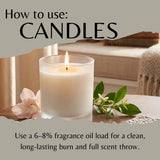 An instructional graphic titled 'How to use: CANDLES' shows a lit white candle in a clear glass jar on a tabletop with a flower and green sprig beside it. Text explains using fragrance oil for a clean, long-lasting burn.