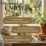Promotional graphic with the text 'Other ways to ENJOY' over a cozy window scene. The image shows a cup of tea, a potted plant, dried orange slices, and layered soap bars on a windowsill, with text overlays listing 'Room Sprays', 'Bath & Body Products', and 'Perfumes'.
