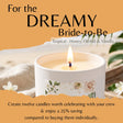 A promotional product graphic for a candle. A white candle in a white vessel is shown lit, with a floral label on the front.