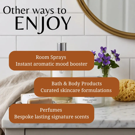 Promotional graphic with the text 'Other ways to ENJOY' over a bathroom countertop scene. The scene includes a room spray bottle, a small vase of purple flowers, a sponge, and a towel, with three orange callout boxes reading 'Room Sprays', 'Bath & Body Products', and 'Perfumes'.