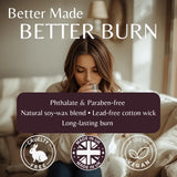 A promotional graphic for Better Made Better Burn cotton wick products, featuring a woman drinking from a glass on a sofa with text overlays highlighting phthalate and parabene-free natural soy-wax blend, lead-free cotton wick, and long-lasting burn. Three circular badges at the bottom indicate cruelty-free, made in UK, and vegan.