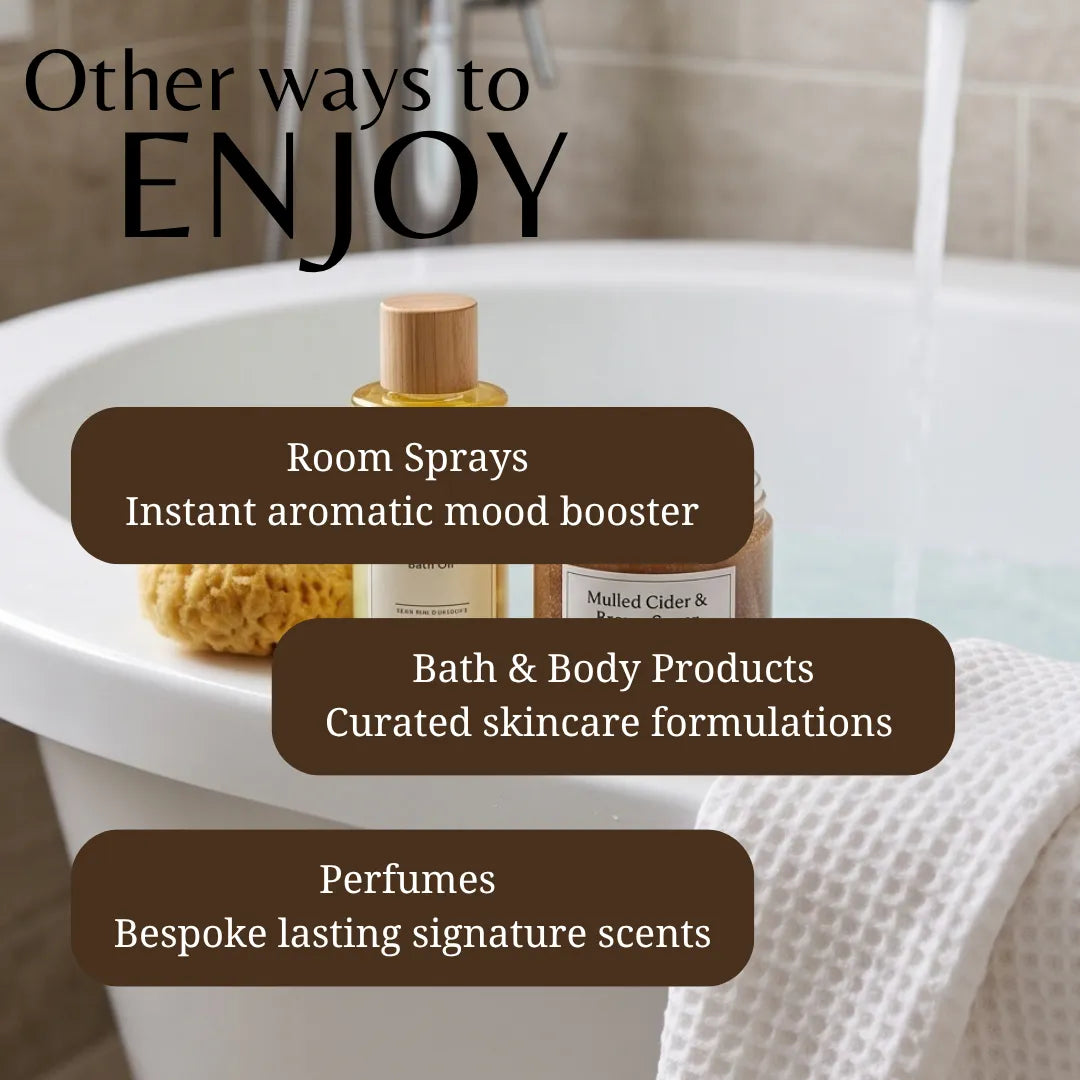 Promotional graphic for bath and body products in a bathroom setting, showing a white bathtub with running water, a wooden-capped bottle, and a folded white towel. Large text reads 'Other ways to ENJOY' with callouts for room sprays, bath & body products, and perfumes.