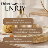 A promotional graphic with the headline 'Other ways to ENJOY' over a styled bathroom-like scene showing a clear room spray bottle, a white candle jar with a gold label, a sponge, and decorative gold tray elements. Three brown text boxes list: Room Sprays, Bath & Body Products, and Perfumes.