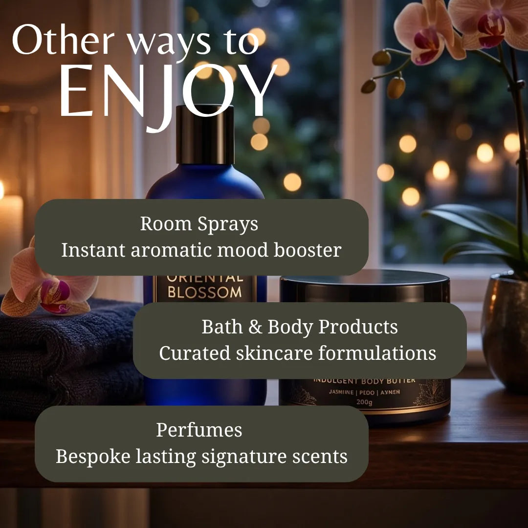 Promotional graphic for fragrance and wellness products with the headline 'Other ways to ENJOY' over a styled tabletop scene. Visible items include an orange-labeled bottle, a dark body butter jar, and text callouts reading 'Room Sprays,' 'Bath & Body Products,' and 'Perfumes.