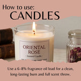 A lit scented candle in a clear glass jar labeled 'ORIENTAL ROSE' with instructional text reading 'How to use: CANDLES' and usage details about fragrance oil load. The candle is shown on a tabletop with books and a jar of dried flowers in the background.