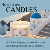 A lit Santorini candle jar in the foreground with a blue-and-white Santorini coastal scene and large text reading 'How to use: CANDLES' and usage instructions on a light blue background.