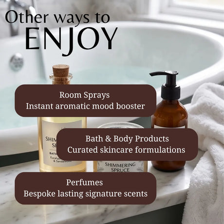 Promotional graphic for bath and body products showing a room spray bottle, amber bath product bottle, and perfume bottle arranged on a marble surface beside a white towel in front of a bathtub. Large text reads 'Other ways to ENJOY' with callouts for room sprays, bath & body products, and perfumes.