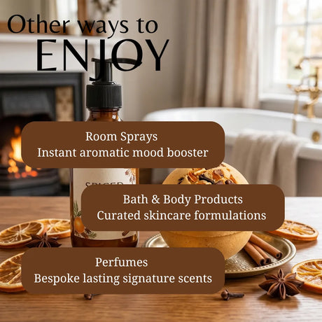 A bottle of scented room spray stands on a wooden table in a warm, cozy interior with a fireplace, bathtub, and dried citrus slices. Large text overlays read 'Other ways to ENJOY' and list uses: room sprays, bath & body products, and perfumes.