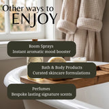 Promotional graphic for a bath and body product collection, featuring a bathtub with a wooden caddy holding a bottle, a candle, and a soap bar in a softly lit bathroom. Large text reads 'Other ways to ENJOY' with callouts for room sprays, bath & body products, and perfumes.