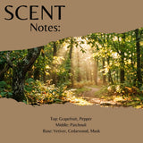 A scent profile graphic with a torn-paper effect showing a sunlit forest path. Large text at top reads 'SCENT Notes:' and smaller text at bottom lists notes: Grapefruit, Pepper, Patchouli, Vetiver, Cedarwood, Musk.