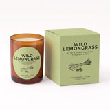 An amber glass candle jar with a round light green label next to its matching light green box. The label and box read 'WILD LEMONGRASS' and 'An NI Candle Supplies Fragrance Oil' with 'Lemongrass - Ginger Green Tea' at the bottom.