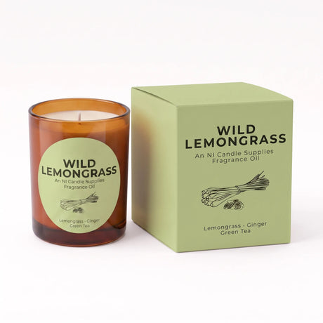 An amber glass candle jar with a round light green label next to its matching light green box. The label and box read 'WILD LEMONGRASS' and 'An NI Candle Supplies Fragrance Oil' with 'Lemongrass - Ginger Green Tea' at the bottom.