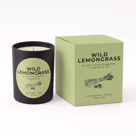 A black candle jar with a light green circular label next to its matching light green box, both printed with the brand name Wild Lemongrass and scent details for Lemongrass - Ginger Green Tea.