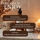 A warm promotional graphic for a spa-like fragrance and bath product collection. The scene shows an amber pump bottle, a rolled beige towel, a candle in a glass holder, and a body scrub jar on a marble surface with overlaid text reading 'Other ways to ENJOY' and descriptions for room sprays, bath & body products, and perfumes.