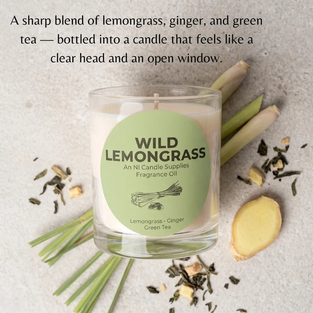 A glass jar candle labeled 'WILD LEMONGRASS' sits on a light stone surface with lemongrass stems, ginger root, and loose tea leaves around it. Text at the top describes the scent as a sharp blend of lemongrass, ginger, and green tea, with the brand NI Candle Supplies visible on the label.