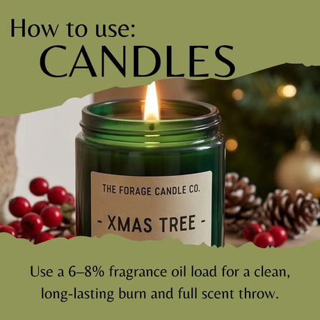 A green glass candle jar labeled 'THE FORAGE CANDLE CO. - XMAS TREE -' with a lit flame, surrounded by red berries, pinecones, and a blurred holiday background.