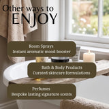 Promotional graphic for home fragrance and bath products, featuring text overlays that read 'Other ways to ENJOY' with bullet points for 'Room Sprays', 'Bath & Body Products', and 'Perfumes'. The background shows a bathroom scene with a bathtub, wooden shelf, candle, and window.