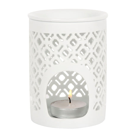 White ceramic lantern with a lit tealight candle on a white background